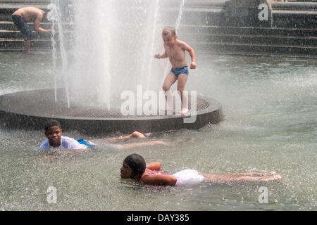 New York, NY 20 July  2013 - Summer heatwave, where temperatures have exceeded 90º farenheit, ( 33º Centigrade ) for the past week, children frolic in the fountain in Washington Square Park.   On Thursday, electricity usage fell just short of an all-time high - 13,161 megawatts were used by 5 p.m., just 28 megawats fewer than a record set on July 22, 2011, Con Edison said, which lead to power outages on Staten Island. City officials urged New Yorkers to avoid exercising outdoors, drink plenty of water and check on any elderly neighbors.