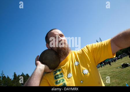 Aaron Monks from Sydney Australia, putting the shot, competing in the Open Heavy Events at the annual Tomintoul Highland games and gathering held on the 3rd Saturday in July, at the showground in the village.  This sporting, historical and traditional event in the previous years, has been beset with bad weather and has been cancelled on several occasions. The Cairngorms National Park is home to some of the best and most famous Highland Games in Scotland. Stock Photo