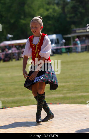 Tomintoul, UK. 20th July, 2013. Highland reel dancers at the annual Tomintoul Scottish games and gathering held on the 3rd Saturday in July, at the showground in the village.  This highland village, hosts a sporting, historical and traditional event during July, in the Cairngorms National Park; One of the best and most famous Highland Games in Scotland. Highland gatherings have a long tradition and history when rival Clans competitors, musicians and dancers, who were important for the prestige of the clan chieftain's, would compete against each other in sporting events. Stock Photo