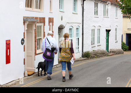 Couple of walkers in High Street, Blakeney, Norfolk, England Stock Photo