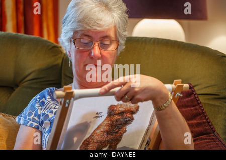 Woman sewing a cross-stitch Stock Photo