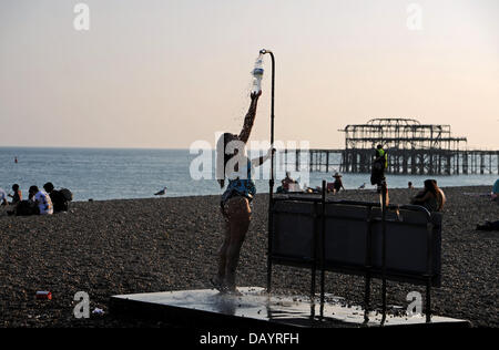 Brighton, UK. 21st July, 2013. A young woman fills her bottle with water from one of the beach showers on Brighton beach Stock Photo