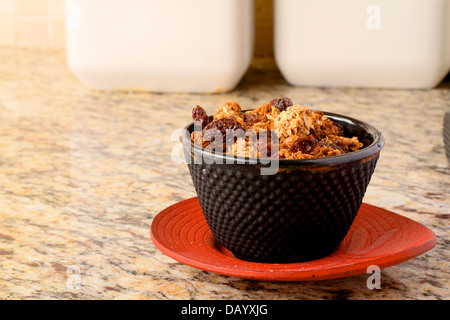 A small bowl of homemade granola on a red dish. Stock Photo