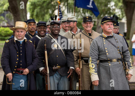 Civil War re-enactors representing the all black 54th Massachusetts Volunteer Infantry with Confederate re-enactors during a ceremony unveiling a memorial honoring the 54th on the 150th anniversary of the assault on Battery Wagner July 21, 2013 in Charleston, SC. The battle memorialized in the movie 'Glory' took place in Charleston and was the first major battle of an all black regiment. Stock Photo