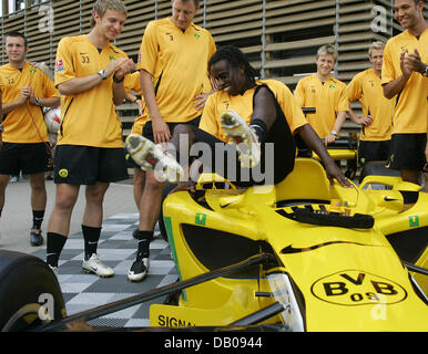 Bundesliga club Borussia Dortmund midfielder Tinga (C) jumps out of the club's race car in Dortmund, Germany, 20 July 2007. Borussia Dortmund will become the newest member in the Superleague Formula, a racing series that aims to combine the emotions of international football with the devotion of motor sports. Along with Borussia Dortmund, Serie A club AC Milan, Ehredivisie club PSV Stock Photo