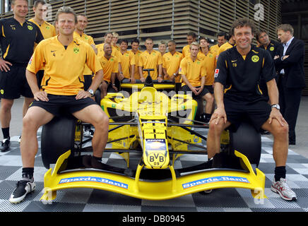 Bundesliga club Borussia Dortmund head coach Thomas Doll (R), skipper Christian Woerns (L) and the team pose with the club's race car unveiled in Dortmund, Germany, 20 July 2007. Borussia Dortmund will become the newest member in the Superleague Formula, a racing series that aims to combine the emotions of international football with the devotion of motor sports. Along with Borussi Stock Photo