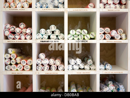 Sticks of seaside rock on sale of various football teams Stock Photo