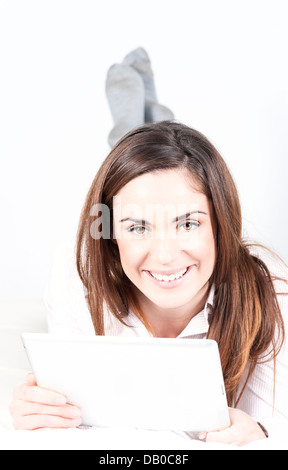 Young smiling woman on sofa with tablet Stock Photo