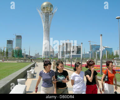 Tourists walk in front of the 100-meter-tall Bayterek Tower, also referred to a 'large lollipop', at the new capital Astana, Kazakhstan, 17 July 2007. The twin office towers by prize winning architect Frank Gehry are seen on the left. Many Kazakhs take it as punishment, that the government forced their relocation to the hostile steppe climate of Astana. Escalating real estate price Stock Photo