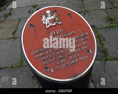 Red plaque commemorating 1930s unemployed in Ardwick Manchester . Demonstration of unemployed marched from Ardwick Green Stock Photo