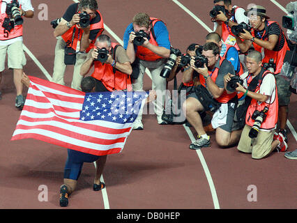 US-American sprinter Tyson Gay celebrates with the US-American flag surrounded by photographers after winning the 200m final at the IAAF World Championships in Athletics at Nagai Stadium, Osaka, Japan, 30 August 2007. Photo: Gero Breloer Stock Photo