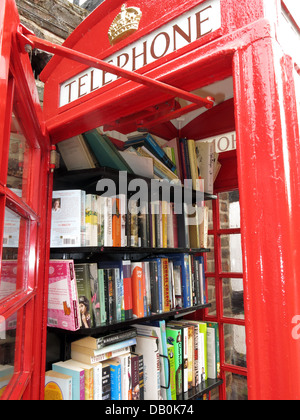 Interior of an old red British Telephone box turned into a British village eccentric lending library Stock Photo