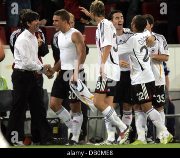 Germany's forward Lukas Podolski (2-L) receives congratulations from the German national coach Joachim Loew (L) and teammates Simon Rolfes (3-L-R), Roberto Hilbert, David Odonkor and Gonzalo Castro after scoring the final 3-1 during the international cap Germany vs. Romania at the RheinEnergie Stadium in Cologne, Germany, 12 September 2007. Photo: Oliver Berg Stock Photo