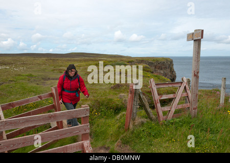 A walker on the clifftop at Mull Head on the Deerness peninsula, Mainland, Orkney. Stock Photo