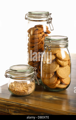 Chocolate and lavender cookies and crushed hazelnuts in a jar on rustic table and white background Stock Photo