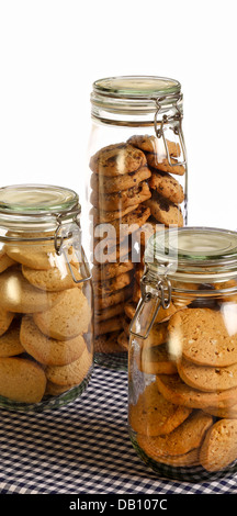 Chocolate, lavender and hazelnut cookies in a jar on rustic table with dark blue gingham tablecloth and white background Stock Photo