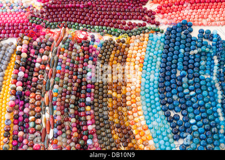 Colourful strings of beads and necklaces on a market stall in Italy, sourced from Punjab, India Stock Photo