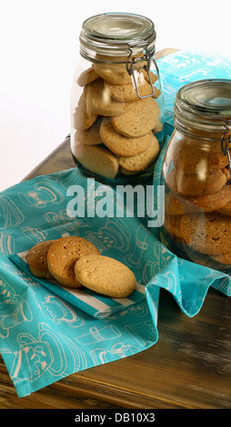 Lavender and Hazelnut cookies on tablecloth and napkin and in jar on rustic table with turquoise tablecloth and white background Stock Photo