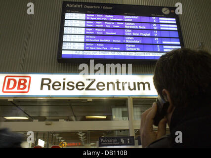 A customer of Deutsche Bahn is pictured talking on his mobile phone in front of a display showing the times of departure of trains at the main train station in Dortmund, Germany, 18 October 2007. The German railway engine drivers union GDL ('Gewerkschaft der Lokomotivfuehrer') continues its third nationwide strike within two weeks affecting short-distance traffic. Customers have to Stock Photo