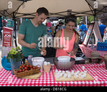 Calgary, Alberta. 21st July, 2013. Man and woman spoon samples for the salsa tasting contest during the Sun and Salsa festival in the Kensington area of Calgary, Alberta, Canada on Sunday, July 21, 2013. This annual event raises funds for charity. Credit:  Rosanne Tackaberry/Alamy Live News Stock Photo