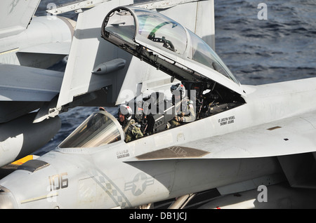Lt. Anthony Clay, left, and Lt. Justin Wiedel, conduct pre-flight inspections on an F/A-18F Super Hornet from the 'Diamondbacks' of Strike Fighter Squadron (VFA) 102 on the flight deck of the U.S. Navy's forward-deployed aircraft carrier USS George Washin Stock Photo