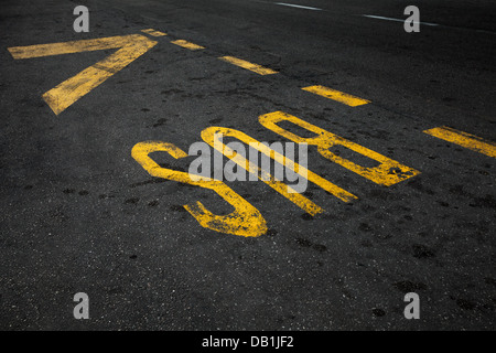 Yellow bus stop marking on urban asphalt road Stock Photo