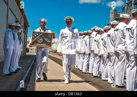 A Sailor carries a shadow box to give to the commanding officer of the guided-missile frigate USS Reuben James (FFG 57) during Stock Photo