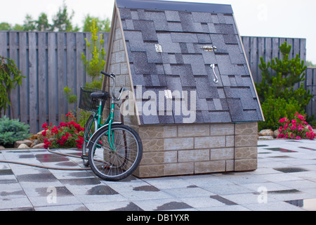 Bike next to a stone pit in the yard Stock Photo