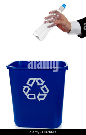 Hand putting an empty water bottle in a blue recycle bin Stock Photo
