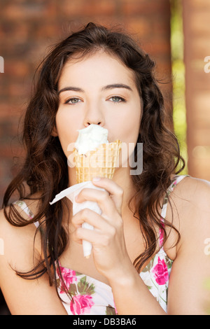 Portrait of young happy woman eating ice-cream, outdoor  Stock Photo