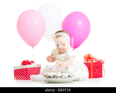 baby girl touching light on birthday cake Stock Photo