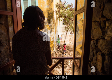 First Lady Michelle Obama looks out a window at local children during her visit to a cultural center on Gorée Island, Senegal, June 27, 2013. Stock Photo