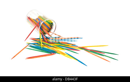 A plastic container spilling colorful toothpicks on to a white background. Stock Photo