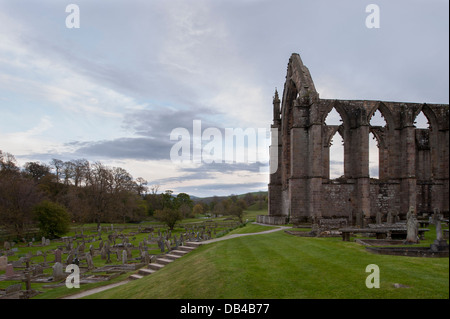 View from north of ancient, picturesque monastic ruins of Bolton Abbey & churchyard headstones, in scenic countryside - Yorkshire Dales, England, UK. Stock Photo