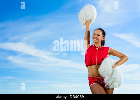 Young cheerleader in red costume with pampon Stock Photo