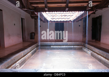 Interior view of Nalukettu with rain pouring from roof Stock Photo