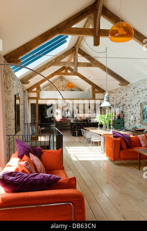 18th century Devon long barn conversion with L-shaped seating unit from Ikea on mezzanine floor Stock Photo