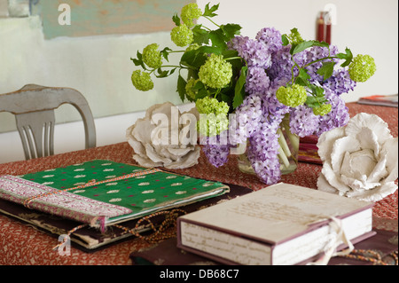 Provencal boutis quilted cloth and white porcelain cabbages with sketch books on tabletop Stock Photo
