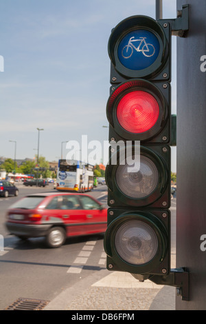 Traffic lights for cyclists, bicycle light turns red, a car cross the cycle way Stock Photo