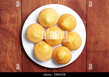 Plain cupcakes on a white plate on table. Top view Stock Photo