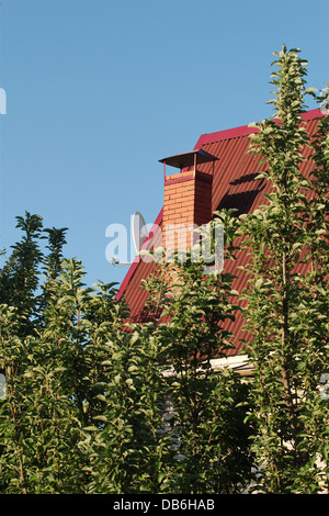 New pipe from the furnace on the roof, on blue sky background Stock Photo