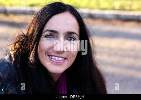 Portrait Of A Mature Healthy Attractive Dark Haired Woman Smiling Stock Photo