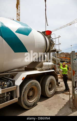 construction workers pouring concrete from delivery truck building site ongoing in Barcelona Catalonia Spain Stock Photo