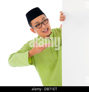 malay male with blank card during hari raya Eid al-Fitr celebration Stock Photo