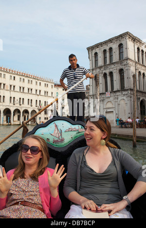 A teenage girl takes a gondola ride with her Auntie along a canal in Venice, ITaly. Stock Photo