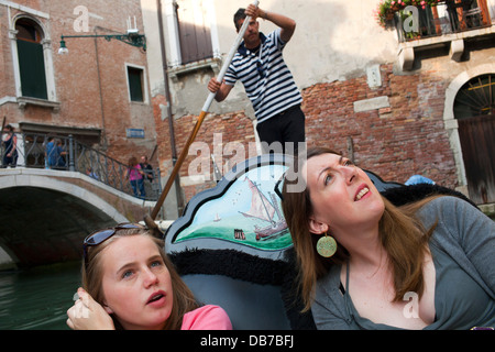 A teenage girl takes a gondola ride with her Auntie along a canal in Venice, ITaly. Stock Photo
