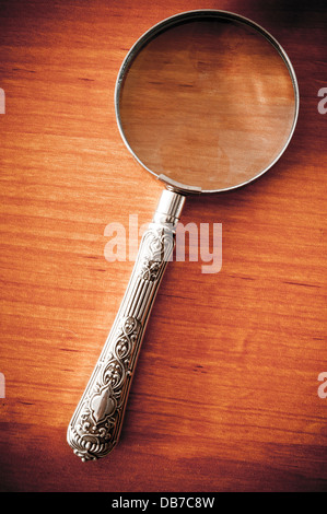 Antique vintage magnifying glass on paper background Stock Photo - Alamy