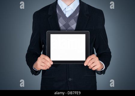 Handsome businessman in black suit showing modern digital tablet with blank screen. Studio shot. Isolated on dark background Stock Photo