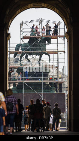 Restorers and journalists stand on the scaffold in front of the bronze equestrian statue of King John of Saxony at the Semper Opera in Dresden, Germany, 25 July 2013. For around 75 000 euros the surfaces of the statue is cleaned from dirt, dust and rust deposits. Created in 1889 by sculptor Johannes Schilling the monument commemorates King John of Saxony (1801-1873), who commissioned the construction of the Semperoper. Photo: Hannibal Stock Photo