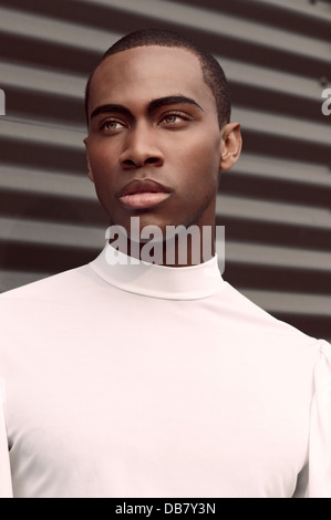 A handsome young black man beauty portrait he wearswhite turtle neck he has full lips and dramatic eyebrown looking to the right Stock Photo
